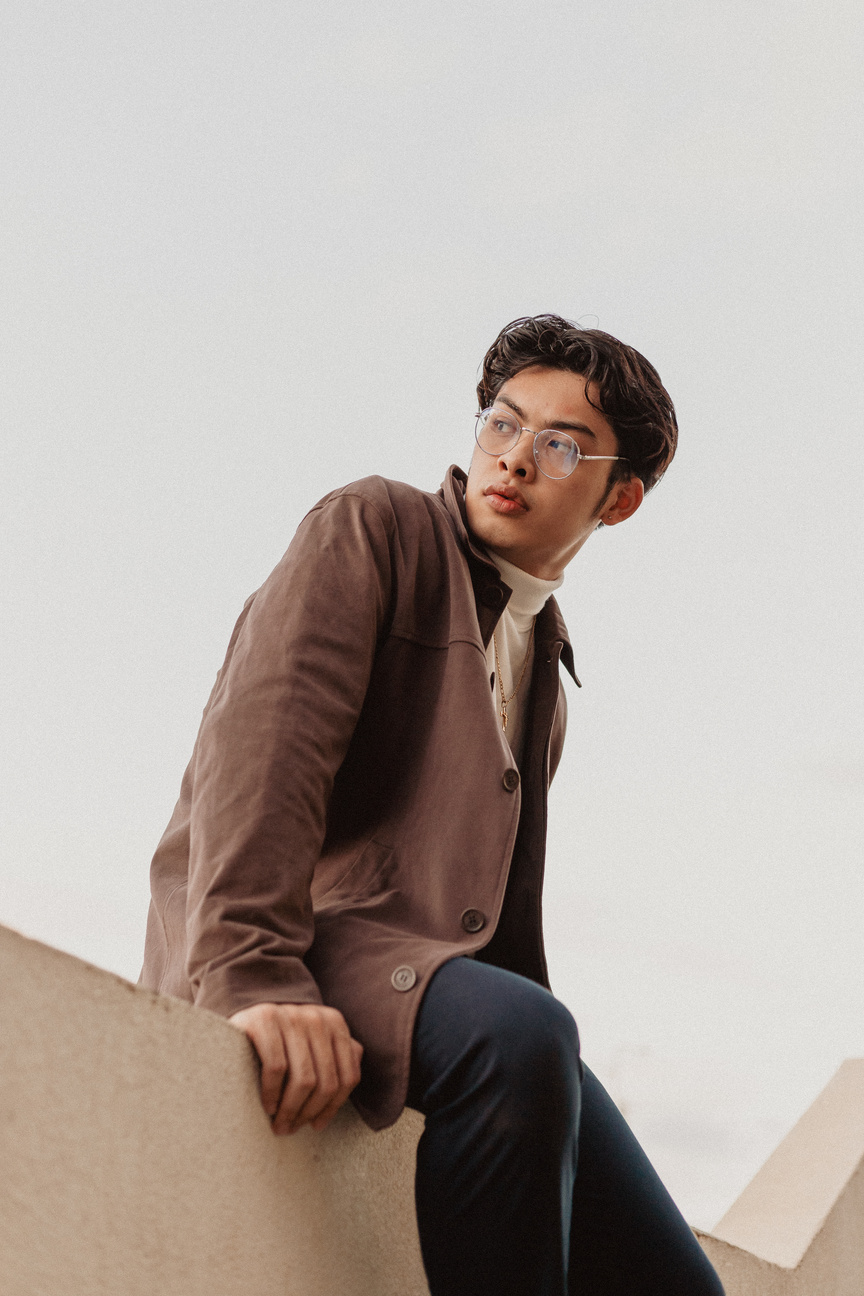 Fashionable Man in Brown Jacket and Eyeglasses Sitting Outdoors